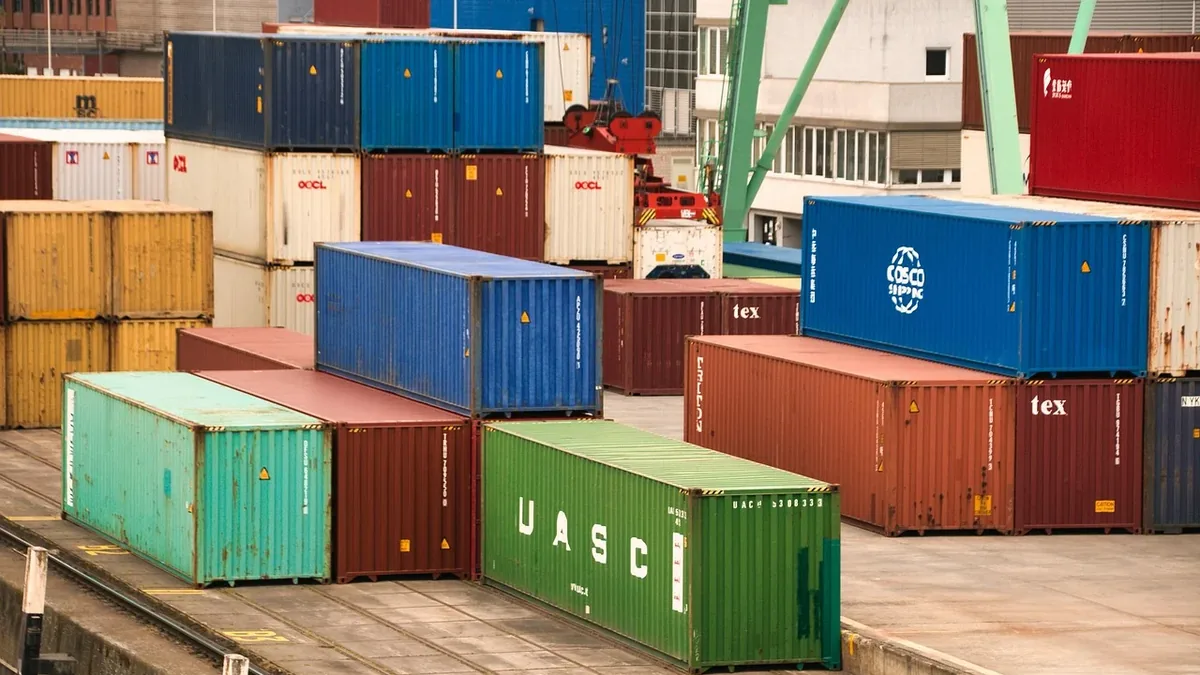 A collection of shipping containers stacked on top of each other, with some containers featuring visible logos and markings.