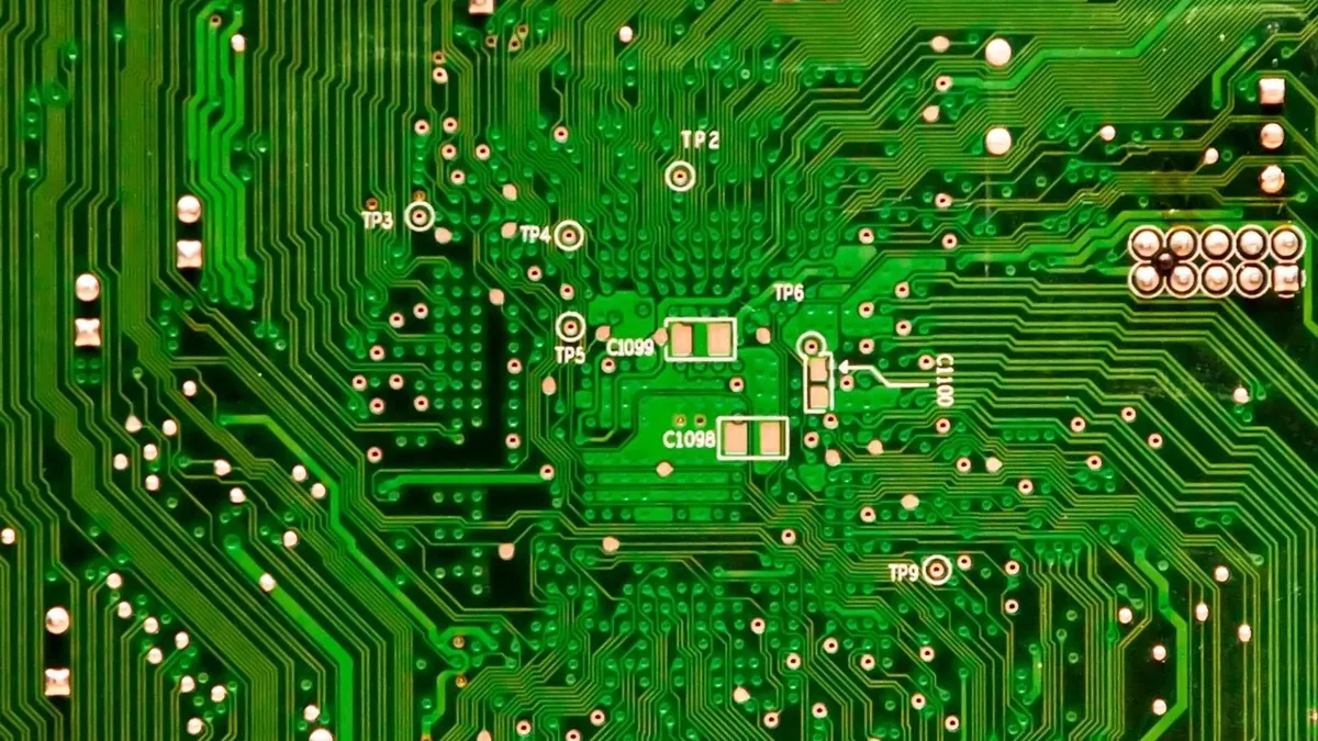 A green circuit board with various components, including capacitors, resistors, and integrated circuits.